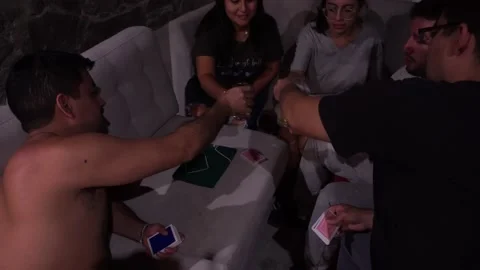 Several friends toasting and playing cards in the living room Vídeos de archivo 199511358