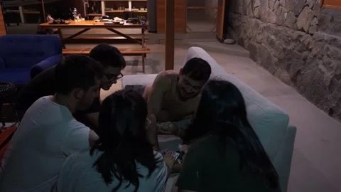 Several friends toasting and playing cards the game “nervous” in the living room Stock-Footage 199512167