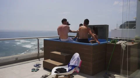 Several friends toasting drinking beer and wine in the pool on the terrace of a Stock Footage 186235438