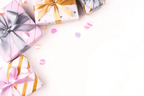 Several gift boxes with bows and confetti on a white background. Stock Photos