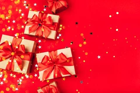 Several gift boxes with bows on a red background. Stock Photos