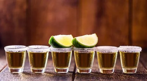 Several glasses of tequila lined up, a drink of Mexican culture, made of dist Stock Photos