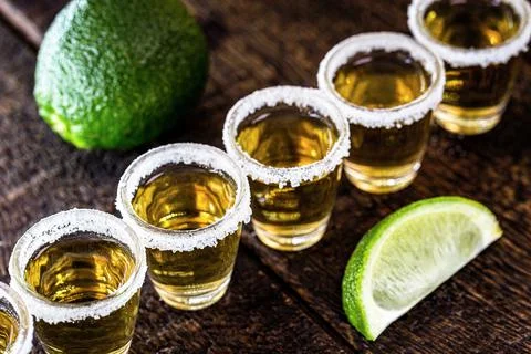 Several glasses of tequila lined up, a drink of Mexican culture, made of dist Stock Photos