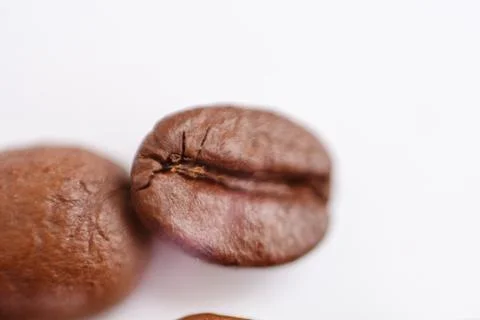 Several grains of roasted coffee on a white background. macro. photographed Stock Photos