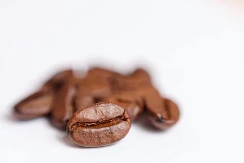Several grains of roasted coffee on a white background. macro. photographed Stock Photos