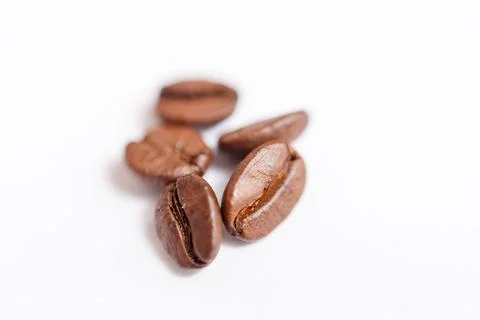 Several grains of roasted coffee on a white background. macro. photographed Stock Photos