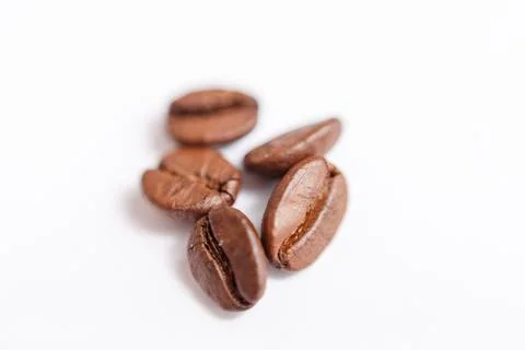 Several grains of roasted coffee on a white background. macro. photographed Stock Photos
