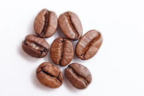 Several grains of roasted coffee on a white background. macro. photographed Stock Photos