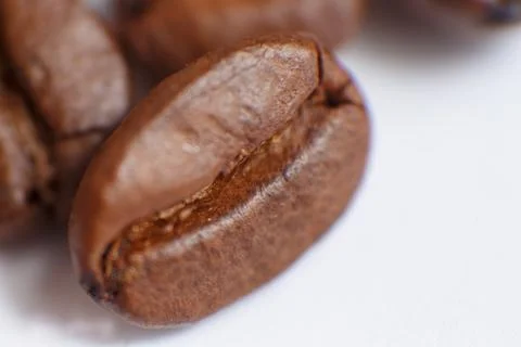 Several grains of roasted coffee on a white background. macro. photographed Stock Photos