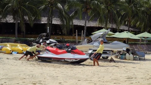 Several guys are pushing a jet ski towards the sea. Video stock 110634438