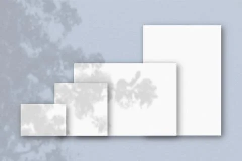 Several horizontal and vertical sheets of white textured paper against a blue Illustrazione stock