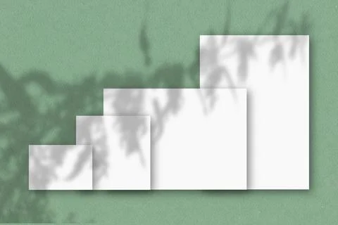 Several horizontal and vertical sheets of white textured paper against a green Stock Illustration