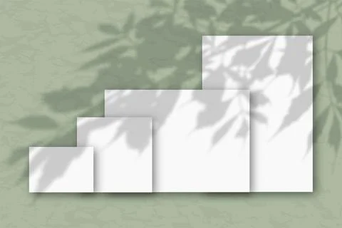 Several horizontal and vertical sheets of white textured paper against a green Stock Illustration
