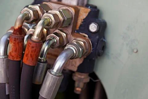 Several hoses mounted with silver-colored bolts are used for hydraulics Stock Photos