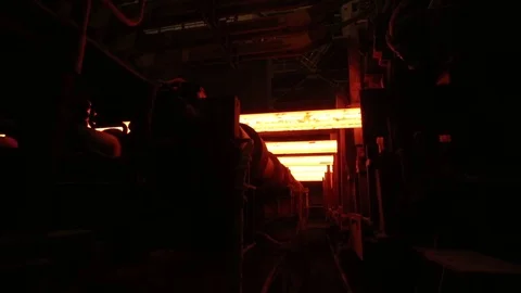 Several hot iron bars moving on the conveyer, shot from the buttom, m/s Stock Footage 72763115