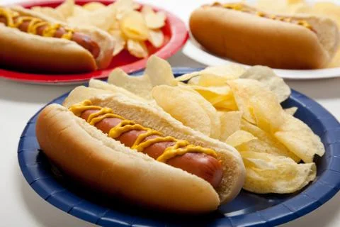Several hotdogs on colored plates Stock Photos