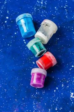 Several jars of different colors paint on galaxy-blue background Stock Photos