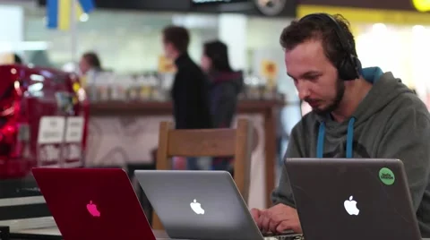 Several laptops, man with headphones programming on ios Stock Footage 57141009