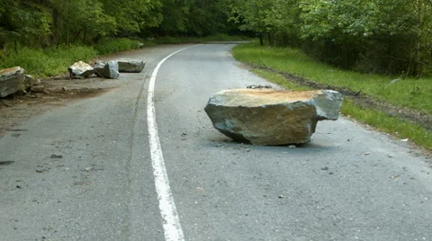 Several large boulders block the road after a rockslide. Blackmagic 4k camera fo Stock Footage 64350425