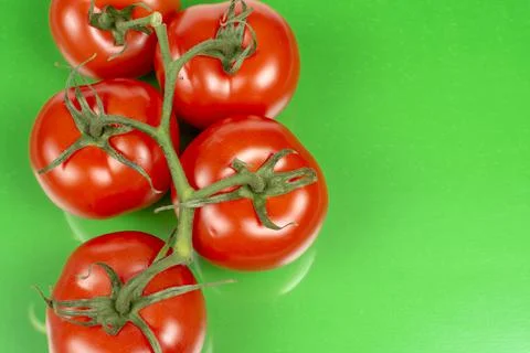 Several large red tomatoes close-up on a green background Stock Photos