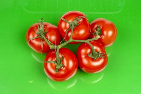 Several large red tomatoes close-up on a green background Foto stock