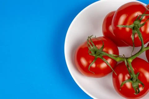 Several large red tomatoes close-up on a blue background Stock Photos