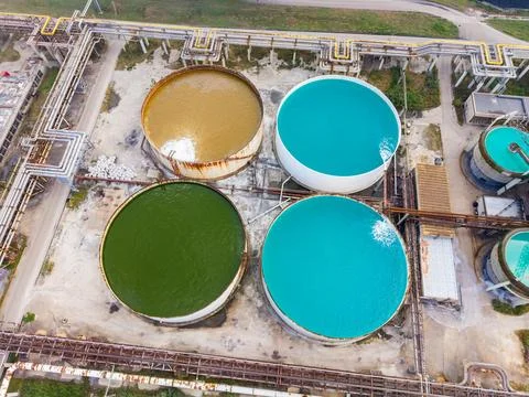 Several large round tanks filled with different colored liquids at an industr Stock Photos