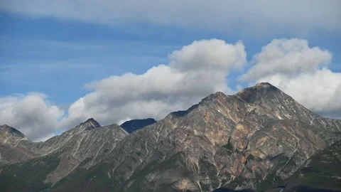 Several large stony brown mountains with white clouds  Stock Footage 152482988