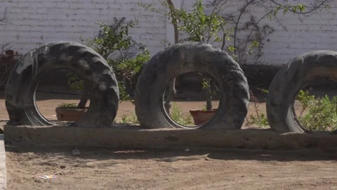 Several large tractor tires embedded in the ground like decoracoin on the street Видео 155822484