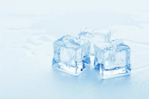 Several melted ice cubes with drops on a light background with blue tinting Foto stock