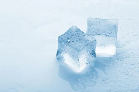 Several melted ice cubes with drops on a light background with blue tinting 写真素材
