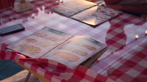 Several menus lie on the table in the restaurant, outdoors, by the water at Video stock 83343663