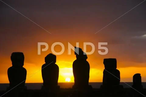 Several moai at Tahai on Easter Island during sunset Stock Photos