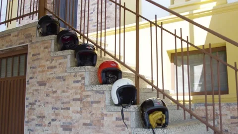 Several motorcycle helmets placed on steps Stock Footage 194744380