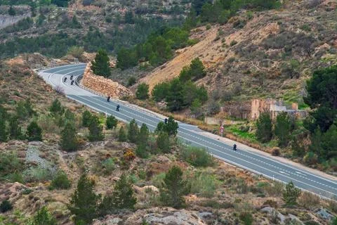 Several motorcycles circulating on a two-way road and with a curve in the m.. Stock Photos