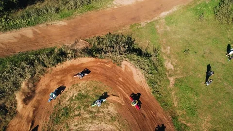 Several motorcyclists enter a turn on a dirt track Stock Footage 284330287