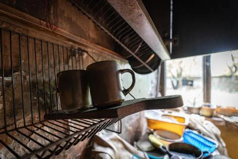 Several mugs placed on a shelf inside a deserted, empty house Foto stock