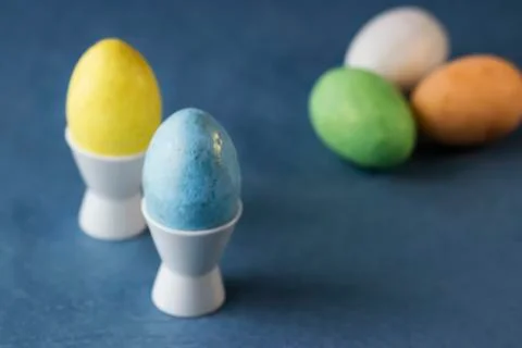 Several multi-colored decorative eggs on a gray background. Easter concept. Stock Photos