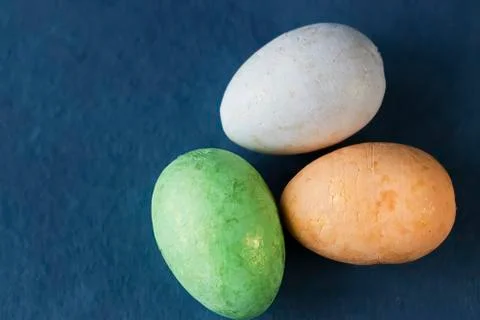 Several multi-colored decorative eggs on blue background. Easter concept. Stock Photos