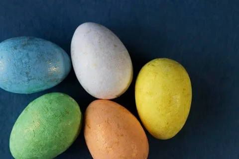 Several multi-colored decorative eggs on blue background. Easter concept. Stock Photos