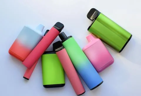 Several multi-colored electronic cigarettes lie on a light table. Foto stock