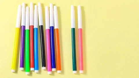 Several multi-colored markers on a yellow background. Stock-Fotos