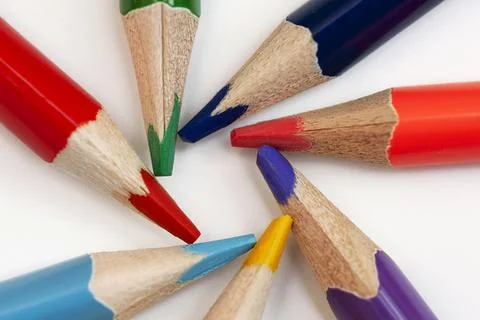 Several multi-colored pencils are arranged in a circle on a white background. Stock Photos
