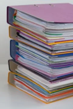 Several multicolored folders with documents stacked in a pile on Stock Photos