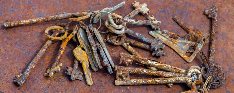 Several old rusty keys on ring shot on steel textured background Stock Photos