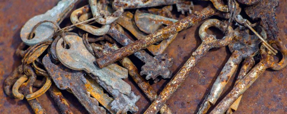 Several old rusty keys on ring shot on steel textured background Stock Photos