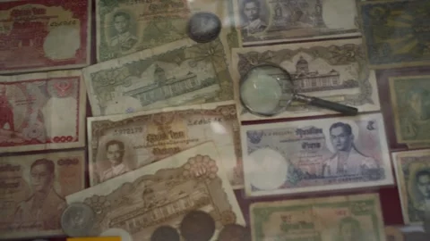 Several old Thai banknotes are placed in a glass cabinet Stock Footage 275592409