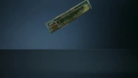 Several one hundred dollar bills fall and pile up on a blue surface. Stock Footage 326748171