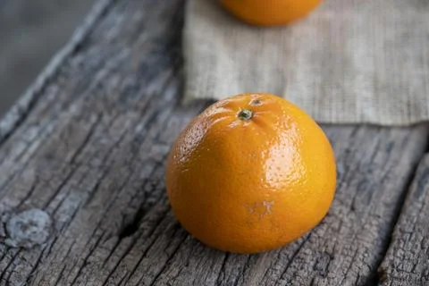 Several oranges fruit and slices in a white plate on an old wooden table Foto stock