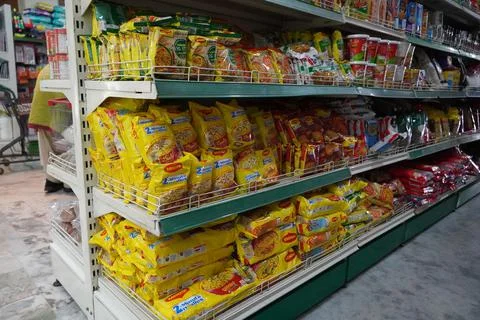 Several packets of packaged noodles kept on shelf for sale. Maggi instant noo Stock Photos
